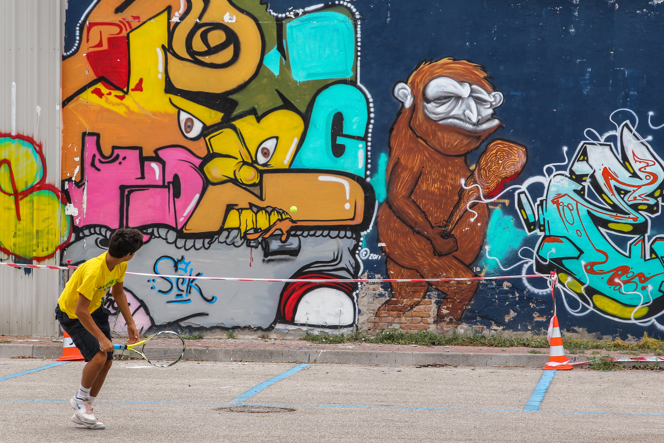 Tennis vor der Graffitiwand – der gemalte Affe schaut zu